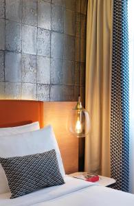 a bedroom with a bed with a lamp and a curtain at Renaissance Paris Vendome Hotel in Paris