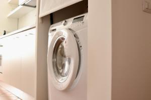 a washer and dryer in a laundry room at Palazzo Palloni Boutique Apartment in Sorano