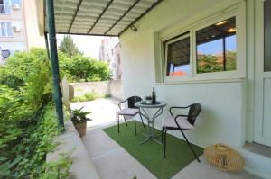 d'une terrasse avec deux chaises et une table sur le côté d'une maison. dans l'établissement Apartment Vinea-parking included, à Šibenik