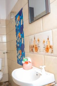 a bathroom with a sink and a mirror at Serene 2 bedroom homestay 15mindrive to the beach in Mombasa