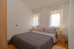 a bedroom with a large bed and two windows at Apartment Senada 1503 in Galižana