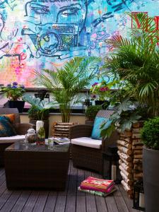 eine Terrasse mit Stühlen und Pflanzen sowie eine Wand mit Graffiti in der Unterkunft Renaissance Paris Vendome Hotel in Paris
