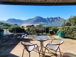 a patio with a table and chairs and mountains at Hout Bay Breeze in Hout Bay