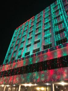 Un palazzo alto con le luci di Natale sopra. di Hotel Razmoni Isha Kha International a Dhaka