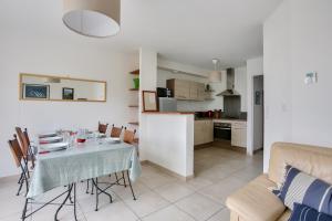 Un comedor y una cocina con mesa y sillas. en Détente et calme sur la Côte d’Émeraude, en Port Blanc