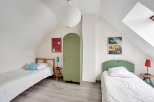 1 dormitorio con 2 camas y puerta verde en Détente et calme sur la Côte d’Émeraude, en Port Blanc