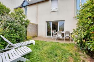 Un patio con una mesa y sillas frente a una casa. en Détente et calme sur la Côte d’Émeraude, en Port Blanc