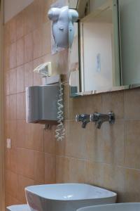 a bathroom with a hair dryer on the wall at Agricampeggio Paradiso in Brenzone sul Garda