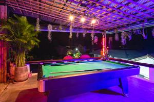 a pool table in a room with purple lighting at Echo Hostel Koh Tao in Koh Tao