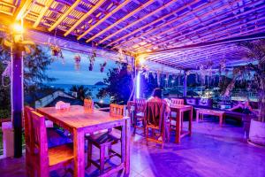 a person sitting at a table on a patio at Echo Hostel Koh Tao in Koh Tao
