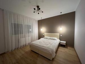 - une chambre avec un lit blanc et un lustre dans l'établissement Gîte « Les Basse des Grouets », à Blois