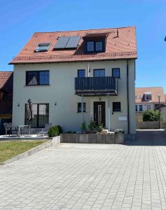 a white house with a roof with solar panels on it at Apartment Sonnenschein in Allersberg