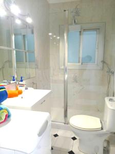 y baño con ducha, aseo y lavamanos. en Liliane Apartment, en Sitges