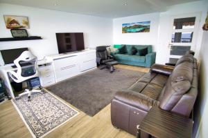- un salon avec un canapé en cuir et une télévision dans l'établissement Ref EGEE - Palmes d'Or Properties, à Cannes