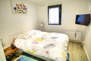 Un dormitorio con una cama y un televisor de pantalla plana. en Ref EGEE - Palmes d'Or Properties, en Cannes