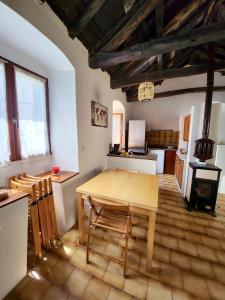 eine Küche und ein Esszimmer mit einem Holztisch und Stühlen in der Unterkunft Maison de 2 chambres avec terrasse amenagee et wifi a Rogliano in Rogliano