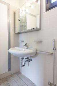 a white bathroom with a sink and a mirror at L'Approdo Hotel in Cesenatico