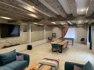 uma sala de estar com uma mesa de pingue-pongue e uma televisão em Gîte « Les Basse des Grouets » em Blois
