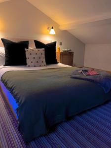 a bedroom with a large bed with black pillows at The Vineyard Lamberhurst in Lamberhurst