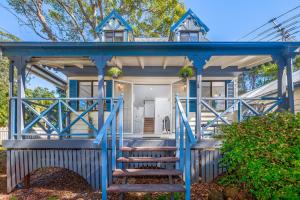 a blue house with stairs leading to the front porch at The Cedar Cottage in Eagle Heights