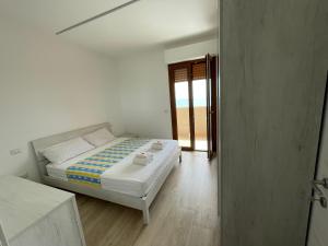 een witte slaapkamer met een bed en een raam bij Oltre le Nuvole in Lido di Fermo