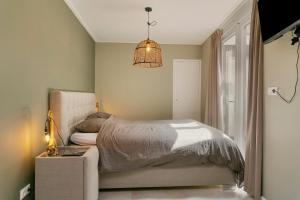 a bedroom with a bed and a chandelier at Verstopt, midden in het centrum van Enschede! in Enschede