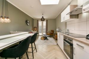 a kitchen with green walls and a counter with chairs at Verstopt, midden in het centrum van Enschede! in Enschede +13 photos