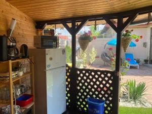eine Küche mit einem weißen Kühlschrank unter einer Pergola in der Unterkunft Vila Amy in Năvodari