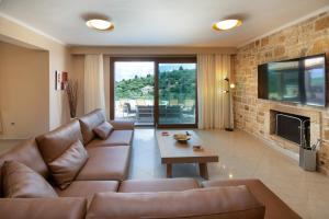 uma sala de estar com um sofá e uma lareira em Villa Ozias a modern,spacious, swimmig pool villa. em Gaios