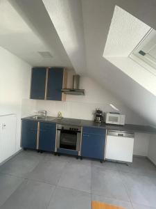 a kitchen with blue cabinets and a stove top oven at Joanna Apartment - MA City 2 in Mannheim