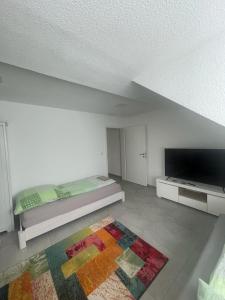 a white room with a bed and a flat screen tv at Joanna Apartment - MA City 2 in Mannheim