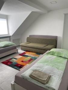 a bedroom with a bed and a couch and a rug at Joanna Apartment - MA City 2 in Mannheim