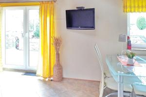 ein Esszimmer mit einem Glastisch und gelben Vorhängen in der Unterkunft Ferienhaus Herz in Lübbenau