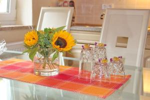 einen Tisch mit einer Vase mit Sonnenblumen darin in der Unterkunft Ferienhaus Herz in Lübbenau