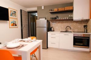 a kitchen with a white table and a refrigerator at Venizelou Comfort & Living I in Kavala +17 photos