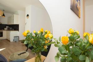 a vase of yellow flowers on a table in a room at Studio and hot tub in Split