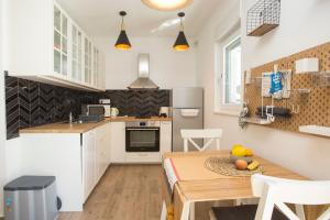a kitchen with a table and a kitchen with white cabinets at Studio and hot tub in Split +14 photos