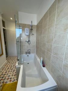 a bathroom with a tub and a shower and a toilet at Nottingham Home Stay in Nottingham