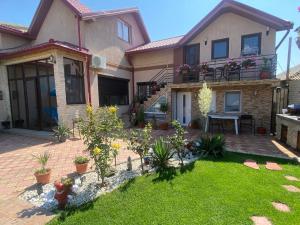 a house with a patio and a yard with plants at Vila Amy in Năvodari