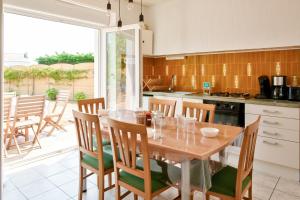 a kitchen with a wooden table and chairs at Parenthese bretonne a Penmarch in Penmarch