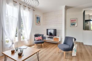 a living room with two chairs and a television at Ambiance paisible sur la côte vendéenne in La Barre-de-Monts