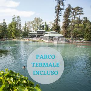 ein Schwimmbad in einem Park mit einem Schild im Wasser in der Unterkunft Parco Termale di Villa Dei Cedri in Colà di Lazise