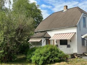 une maison blanche avec un toit marron et des arbres dans l'établissement Oslo House, Nedre Kjellerstuvei, First floor, Twin Room, à Lillestrøm