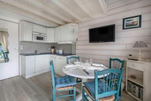 una cucina e una sala da pranzo con tavolo e sedie di Appartement en résidence avec piscine a Batz-sur-Mer Altre 5 foto