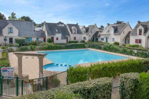 una piscina in un quartiere residenziale con case di Appartement en résidence avec piscine a Batz-sur-Mer