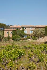 un bâtiment au milieu d'un champ avec des plantes dans l'établissement La Bastide du Mourre, à Oppède