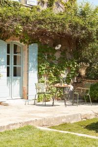 a table and chairs in front of a building at La Bastide du Mourre in Oppède