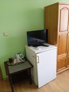 a small white refrigerator with a tv on top of it at Къща за гости Ганчеви in Sozopol