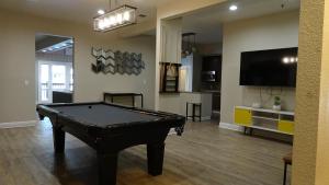 a living room with a pool table and a flat screen tv at Blue Lagoon near Apple in Santa Clara