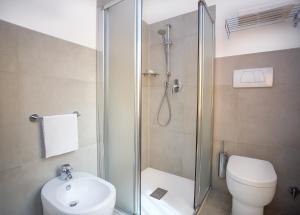 a bathroom with a shower and a toilet and a sink at Camping Village Baia Azzurra Club in Castiglione della Pescaia